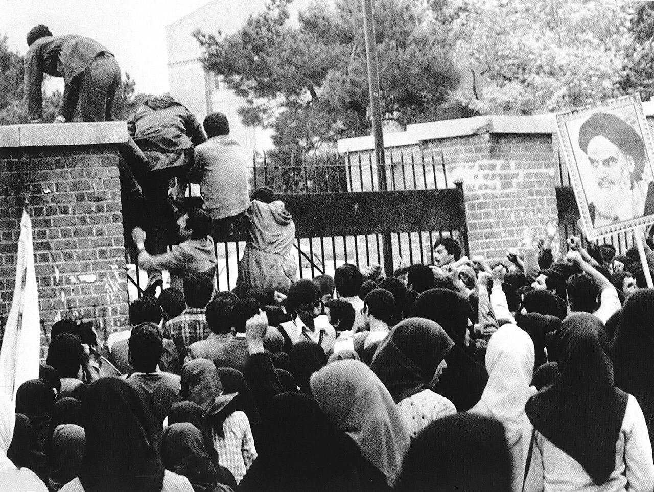 https://en.wikipedia.org/wiki/Iran_hostage_crisis#/media/File:Iran_hostage_crisis_-_Iraninan_students_comes_up_U.S._embassy_in_Tehran.jpg/2